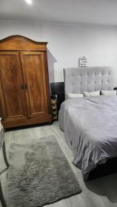 ein Schlafzimmer mit einem großen Bett und einem Holzschrank in der Unterkunft Appartement attique Strasbourg in Straßburg