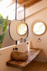 a bathroom with a mirror and a wooden sink at Hotel Tahiti in Puente Iglesias