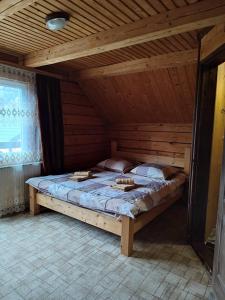 Bett in einem Zimmer mit Holzdecke in der Unterkunft Садиба Гуцульський Двір in Worochta