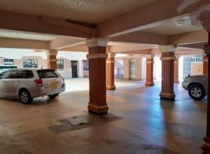ein Parkplatz mit Säulen und Autos in einem Gebäude in der Unterkunft Homestyle Haven with Secure Parking & Free WiFi in Embu
