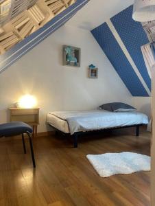 uma cama num quarto com um tecto azul e branco em Charmante maison 10 mn Center Parcs Ailette em Laon