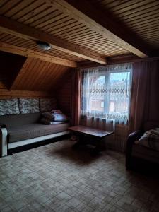 Cette petite chambre comprend un lit et une fenêtre. dans l'établissement Садиба Гуцульський Двір, à Vorokhta