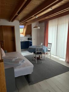 a bedroom with a table and chairs and a kitchen at Gästehaus Elisabeth in Weisenheim am Sand