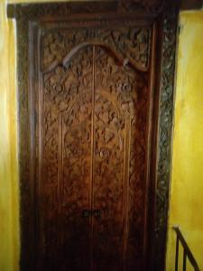 uma porta de madeira com entalhes intrincados em Eco Hotel La Jicarita em Coatepec