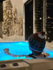 eine Person in einem Schwimmbad mit einem Vogel auf dem Kopf in der Unterkunft Villa Auroras Pöllö in Syöte