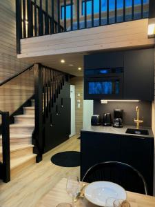 a kitchen with a dining table and a staircase at Villa Auroras Pöllö in Syöte