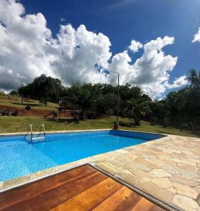 a large swimming pool with a blue at Chácara em Guararema in Guararema