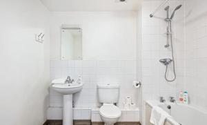 a white bathroom with a toilet and a sink at Bright & Immense 2 BDR Flat near Excel Center in London