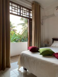a bedroom with a bed and a large window at Sunshine Holiday Home at Wattala in Wattala