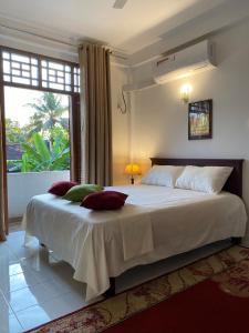 a bedroom with a large white bed with a window at Sunshine Holiday Home at Wattala in Wattala