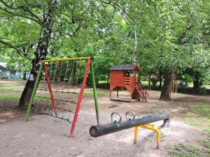 un parque con parque infantil con columpio en Szoba kilátással apartman, en Gárdony