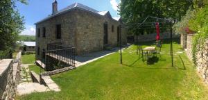 un antiguo edificio de piedra con un patio con una mesa en Guesthouse Kontogianni - Materka, en Nymfaio