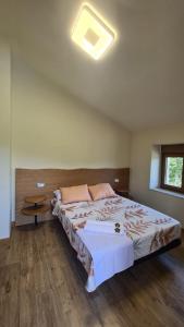 Un dormitorio con una cama grande y una ventana en CASA RURAL LALLANTA en Pedroso