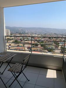 a chair sitting on a balcony with a view at Valpo y su encanto, a pasos de Viña y la costa in Viña del Mar
