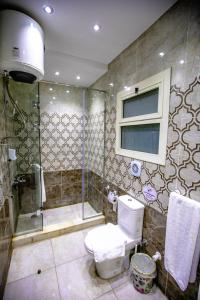 La salle de bains est pourvue d'une douche et de toilettes. dans l'établissement Pyramids Chillout Hotel, au Caire
