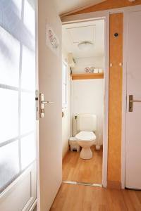 a bathroom with a toilet and a door open at ZALUAY - Mobile Homes in Isla Cristina +37 photos