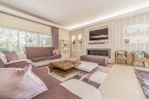 ein Wohnzimmer mit einem Sofa und einem Tisch in der Unterkunft Villa das Giestas in Quinta do Conde