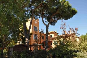 an orange house with trees in front of it at Podere La Branda in Vetralla
