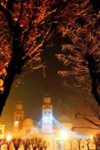 a lit up building with a clock tower at night at Camere Nordest Sudest- Conca Agordina in Agordo