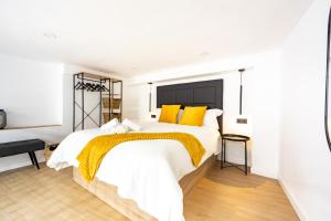 ein Schlafzimmer mit einem großen weißen Bett mit gelben Kissen in der Unterkunft Loft 11 A in Murcia