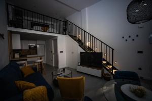 sala de estar con sofá azul y escalera en Loft 11 A en Murcia