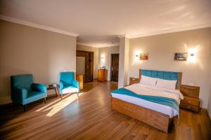 - une chambre avec un lit et deux chaises bleues dans l'établissement Pyramids Chillout Hotel, au Caire