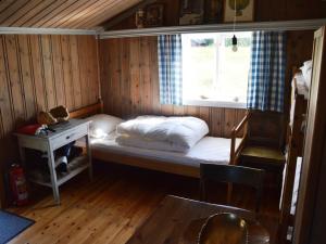 a small room with a bed and a window at Hytte anno 1721 uten internett, strøm, vann - men med rødmalt utedo in Ljørdal