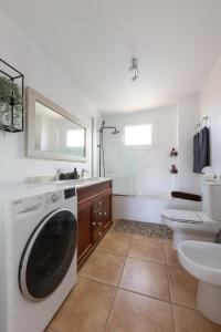 ein Badezimmer mit einer Waschmaschine und einem Waschbecken in der Unterkunft Casa Nahia in Corralejo
