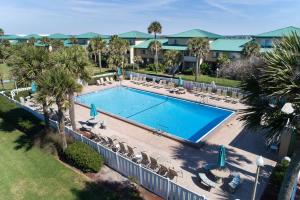 uma vista sobre uma piscina com cadeiras e árvores em Seaspray Condos 115B em Fort Walton Beach