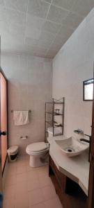 uma casa de banho branca com um lavatório e um WC em Casa Tuzos em Pachuca de Soto
