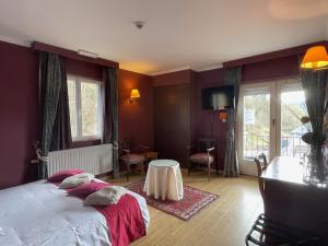 Le Cosy Hotel Restaurant في بوالون: غرفة نوم فيها سرير وطاولة فيها