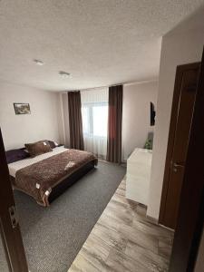a hotel room with a bed and a window at Pensiunea Solca in Solca