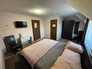 a bedroom with a bed and a desk and chairs at Pensiunea Solca in Solca