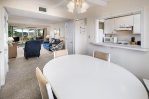 - une salle à manger et un salon avec une table et des chaises blanches dans l'établissement Seaspray Condos 107B, à Fort Walton Beach