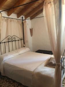 1 dormitorio con 1 cama blanca con dosel en Finca el Fuenton en Málaga