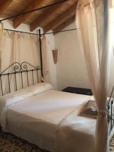 a bedroom with a white bed with a canopy at Finca el Fuenton in Málaga