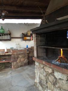 La cocina está equipada con horno de piedra y fogones. en Finca el Fuenton en Málaga