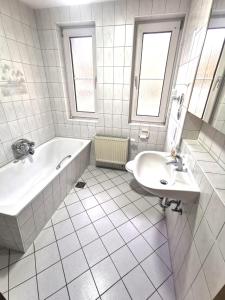 a white bathroom with a tub and a sink at Monteurzimmer am Bahnhof Biesenthal - 2 große Apartments in Biesenthal