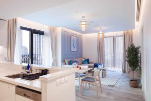 a kitchen and living room with a table and a couch at Trophy - Ahad Residence Business Bay Suite in Dubai