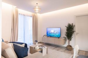a living room with a couch and a flat screen tv at Trophy - Ahad Residence Business Bay Suite in Dubai