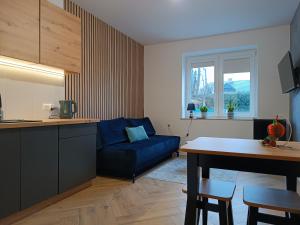 cocina y sala de estar con sofá azul en Apartamenty Centrum, en Janów Lubelski