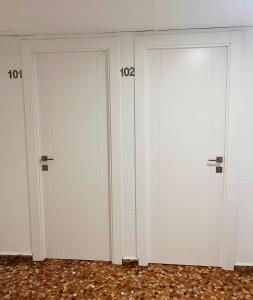 three white doors with numbers on them in a room at Ana Belén in Granada