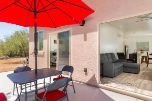 a dining room with a table and a red umbrella at Vista Montaña in Tucson