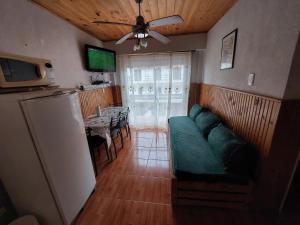 a living room with a green couch and a table at Sol y Luna Hospedajes in San Bernardo
