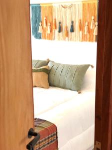 1 dormitorio con cama blanca y espejo en Cielos de Maimará en Maimará
