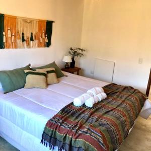 Un dormitorio con una gran cama blanca con almohadas. en Cielos de Maimará en Maimará