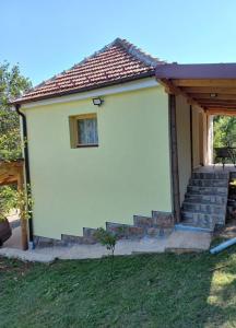 Cette petite maison blanche dispose d'un escalier et d'une fenêtre. dans l'établissement Apartman Tošić, à Trnava