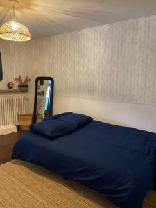 a bed with blue pillows in a bedroom at Appartement avec jardin privé à 10 min de Disneyland, idéal familles in Couilly-Pont-aux-Dames