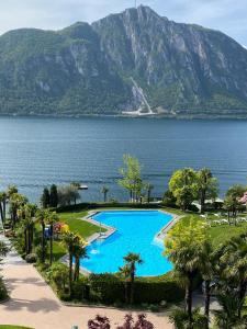 a swimming pool with a view of the water and mountains at Seeblick Bissone in Bissone