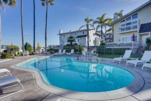 uma piscina com espreguiçadeiras e um edifício em Huntington Beach Condo - Walk to the Ocean! em Huntington Beach